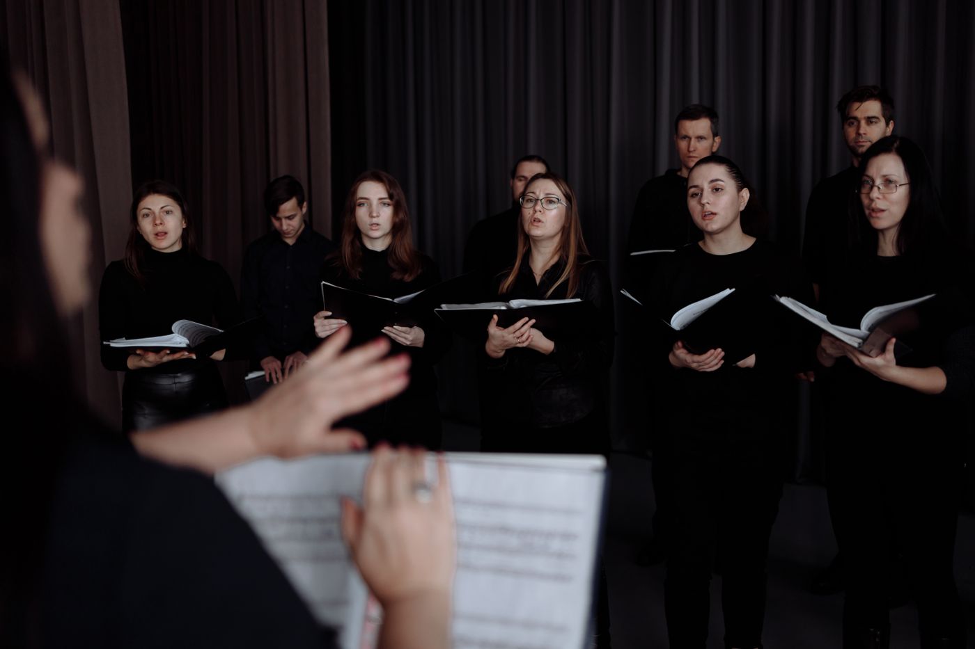Adult choir members rehearsing with their music